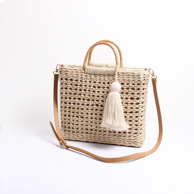 Handcrafted straw shoulder bag with decorative tassel pendant LoungeYard — product view 2