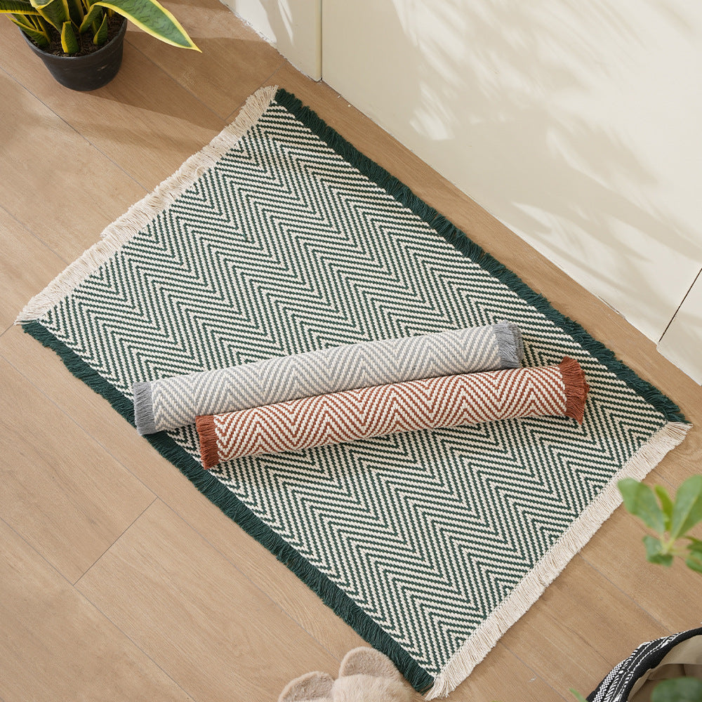 Handwoven cotton bath mat with herringbone pattern and fringes LoungeYard — product view 1